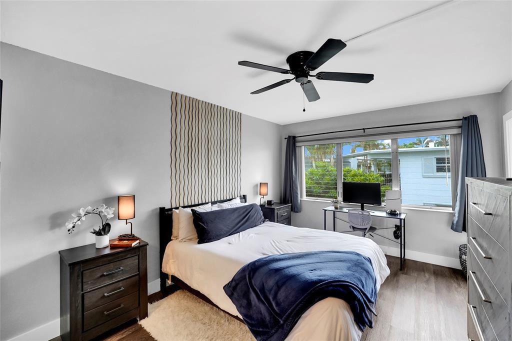 2161 Northeast 42nd Court, Unit 215 Lighthouse Point, FL 33064 - Photo 23 of 50 a bedroom with a bed and wooden floor