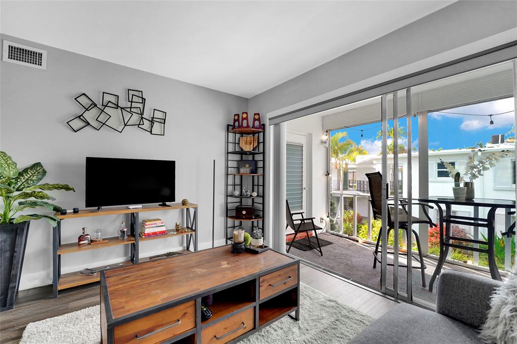 2161 Northeast 42nd Court, Unit 215 Lighthouse Point, FL 33064 - Photo 4 of 50 a bedroom with furniture and a flat screen tv