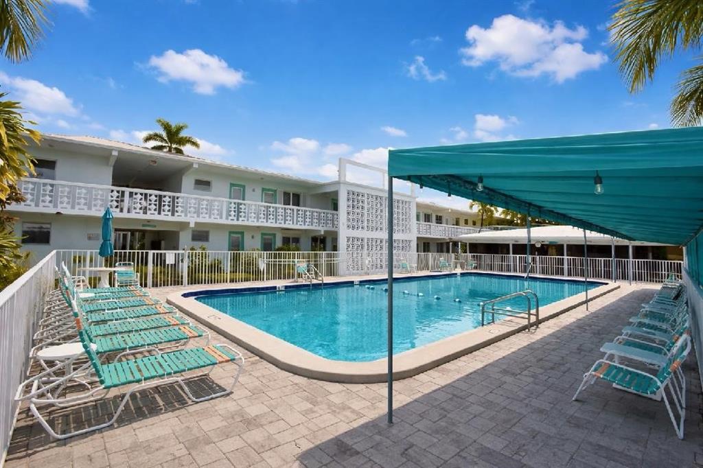 2161 Northeast 42nd Court, Unit 215 Lighthouse Point, FL 33064 - Photo 50 of 50 a view of a swimming pool with an outdoor seating and deck