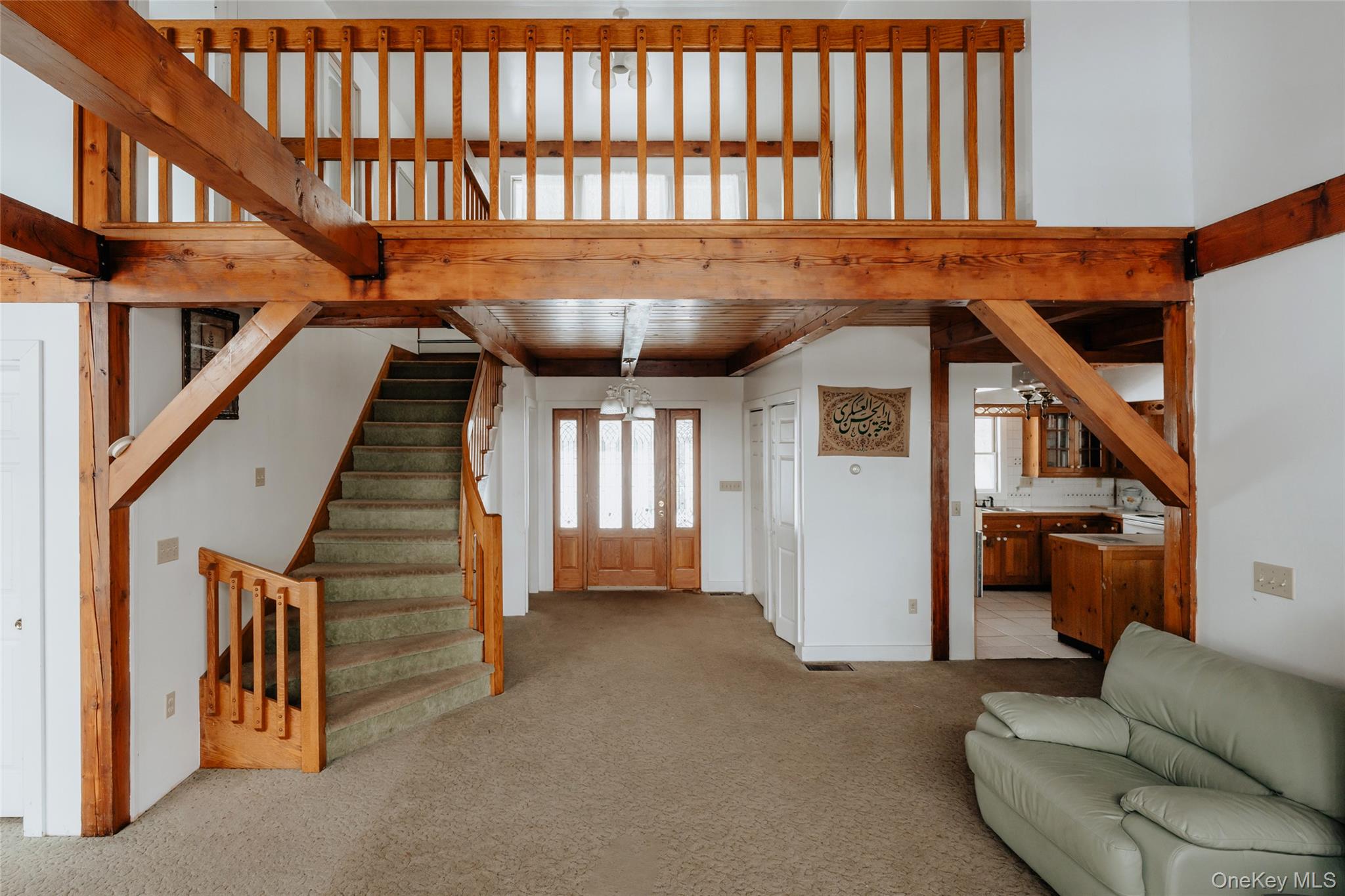 26 Beckys Hill Road Loch Sheldrake, NY 12759 - Photo 17 of 50 Unfurnished living room with light colored carpet, a towering ceiling, and stairway