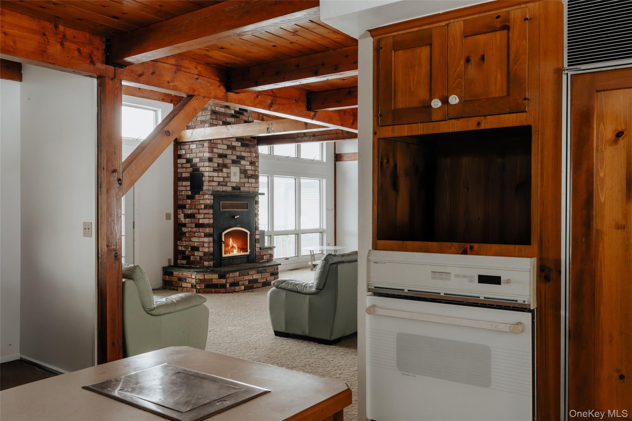 26 Beckys Hill Road Loch Sheldrake, NY 12759 - Photo 35 of 50 Carpeted living room featuring a wooden ceiling with exposed beams and a brick fireplace
