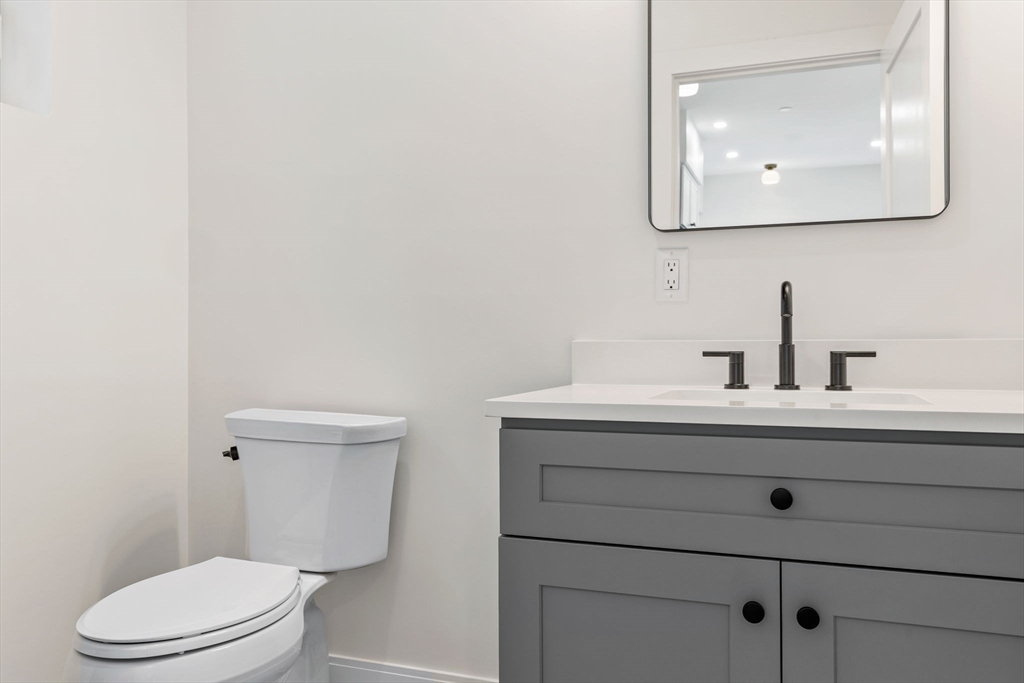 148 Myrtle Street, Unit 4 Melrose, MA 02176 - Photo 11 of 35 a bathroom with a toilet a sink and mirror