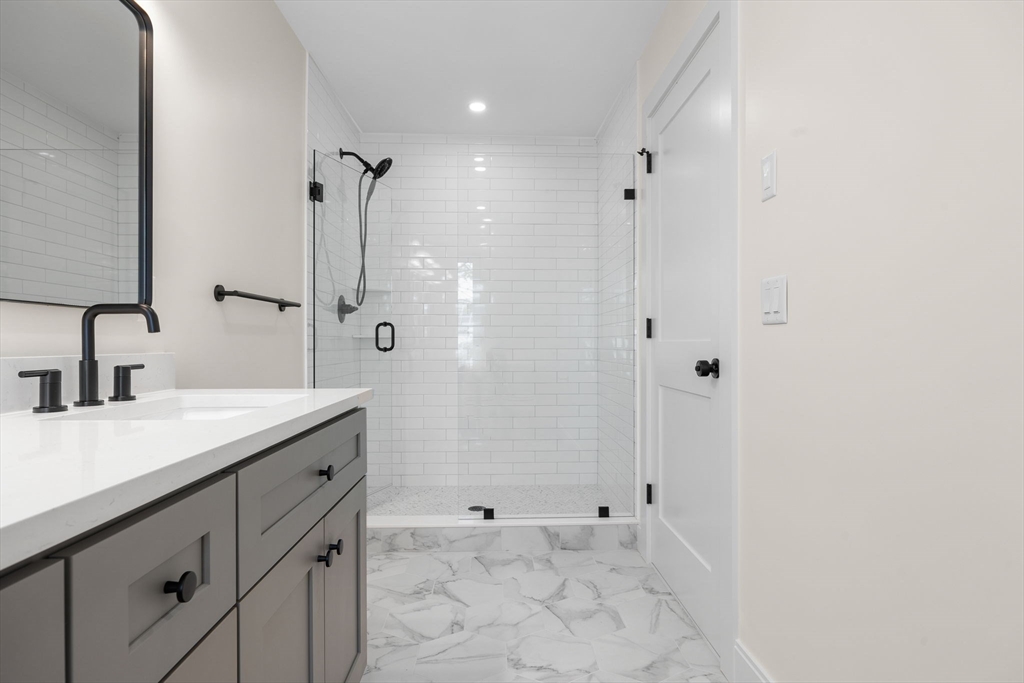 148 Myrtle Street, Unit 4 Melrose, MA 02176 - Photo 15 of 35 a bathroom with a shower sink and mirror