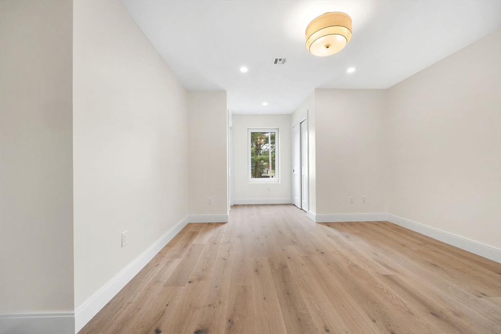 148 Myrtle Street, Unit 4 Melrose, MA 02176 - Photo 17 of 35 an empty room with wooden floor and windows