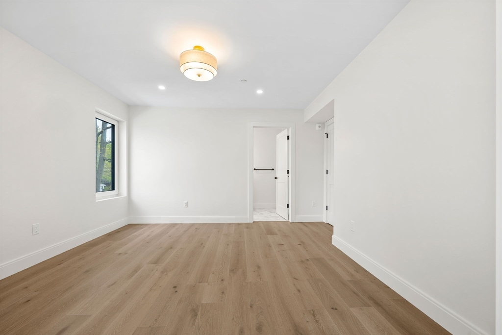 148 Myrtle Street, Unit 4 Melrose, MA 02176 - Photo 18 of 35 an empty room with wooden floor and windows