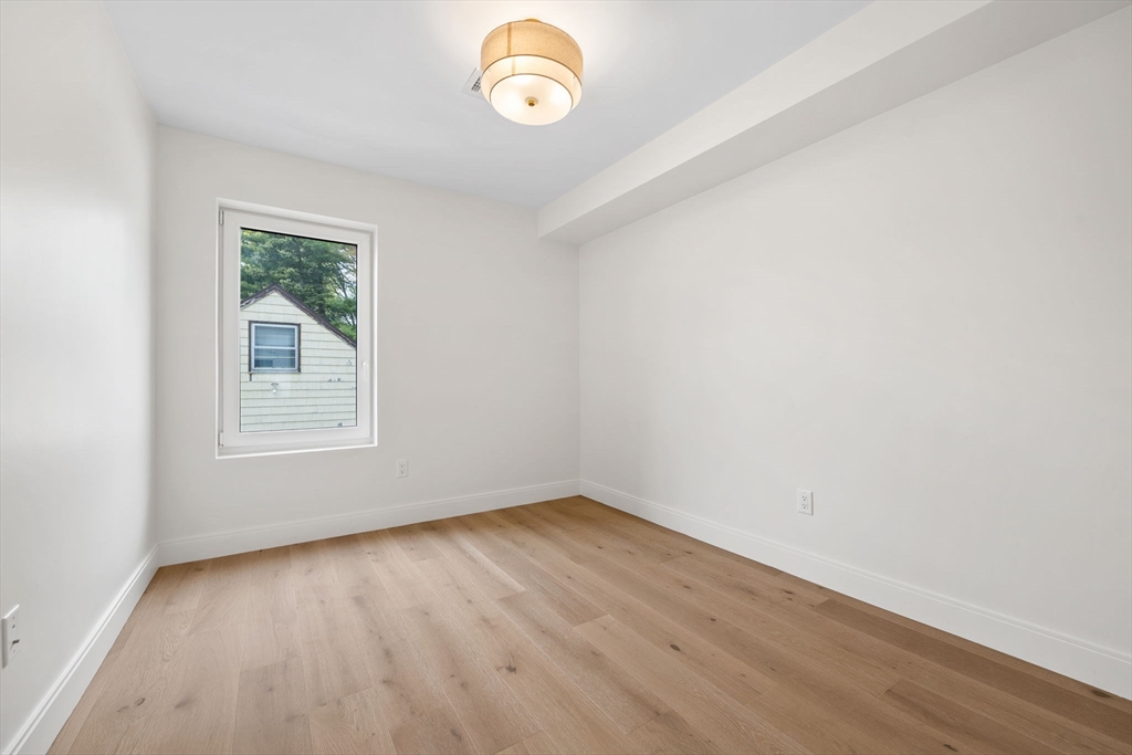 148 Myrtle Street, Unit 4 Melrose, MA 02176 - Photo 20 of 35 an empty room with wooden floor and windows