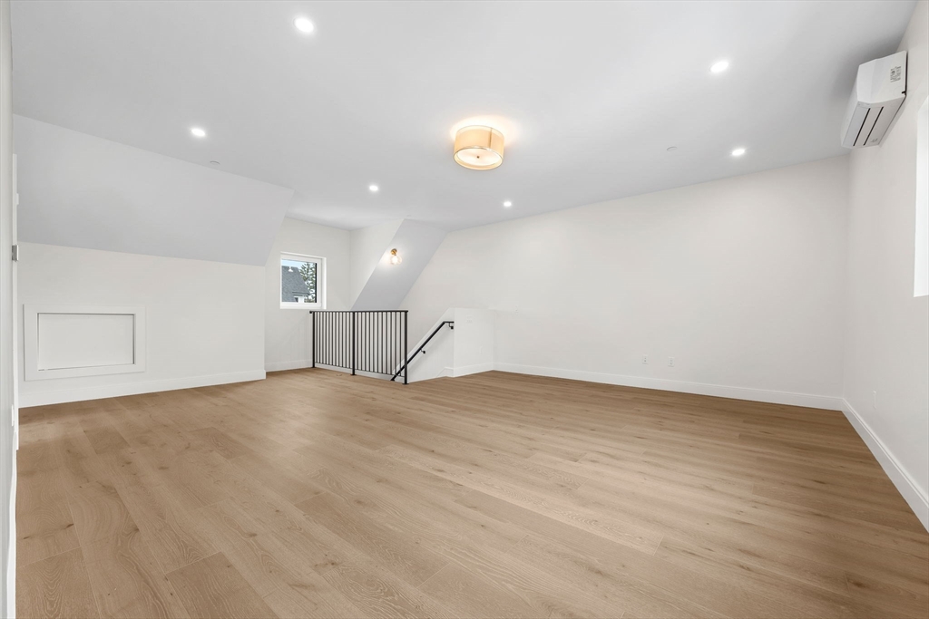 148 Myrtle Street, Unit 4 Melrose, MA 02176 - Photo 23 of 35 a view of an empty room with wooden floor and kitchen space