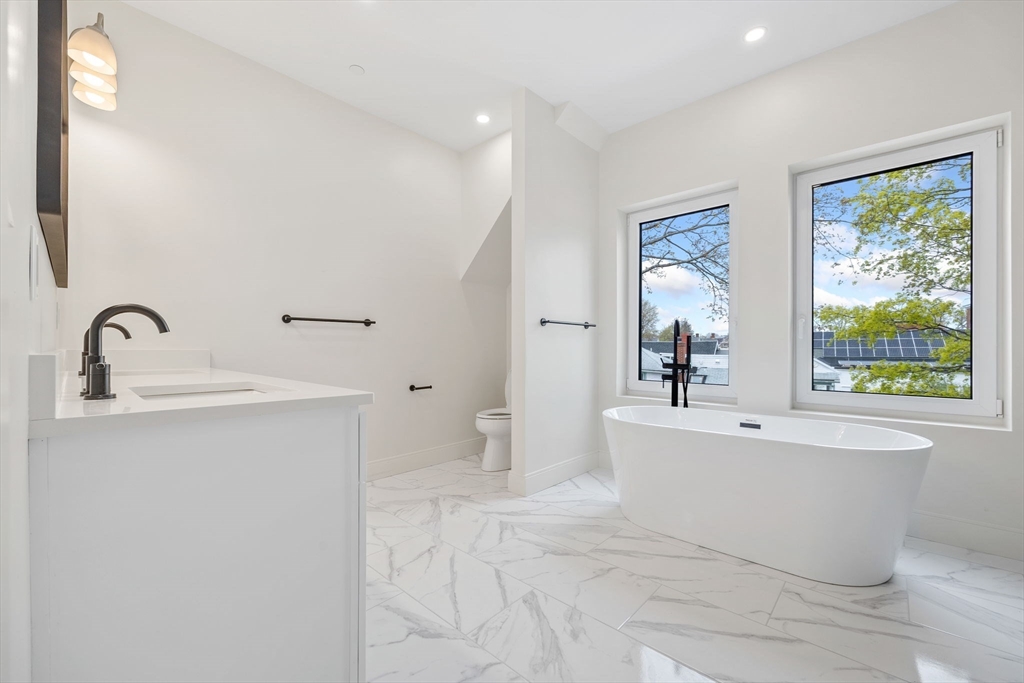 148 Myrtle Street, Unit 4 Melrose, MA 02176 - Photo 25 of 35 a white bath tub sitting next to a white sink