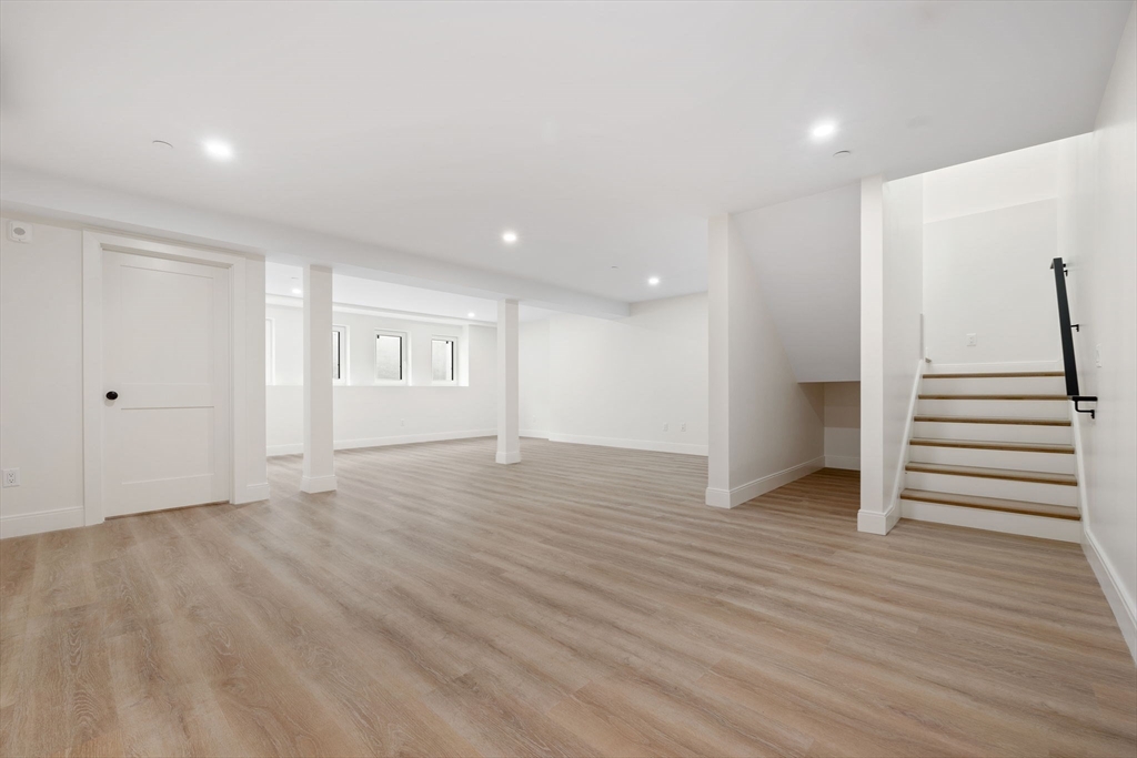 148 Myrtle Street, Unit 4 Melrose, MA 02176 - Photo 10 of 35 a view of an empty room with wooden floor and stairs