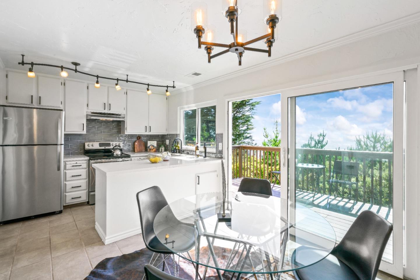 623 Hickey Boulevard, Unit B Pacifica, CA 94044 - Photo 9 of 25 a kitchen with stainless steel appliances granite countertop a stove a refrigerator a kitchen island a table and chairs