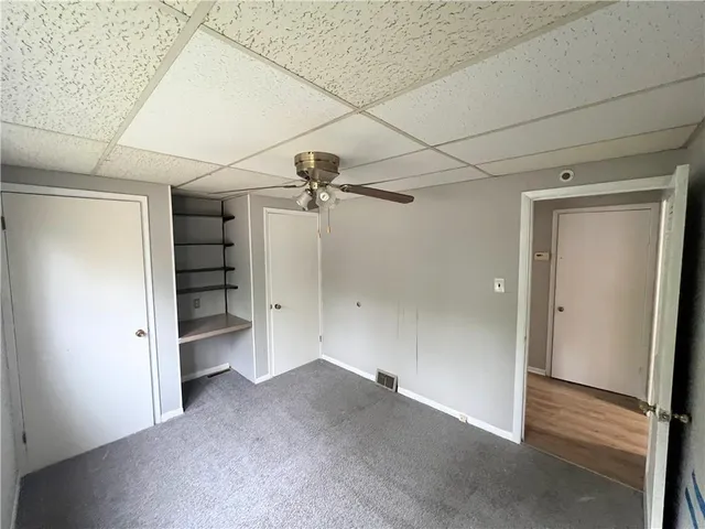 a view of empty room with a windows and a ceiling fan