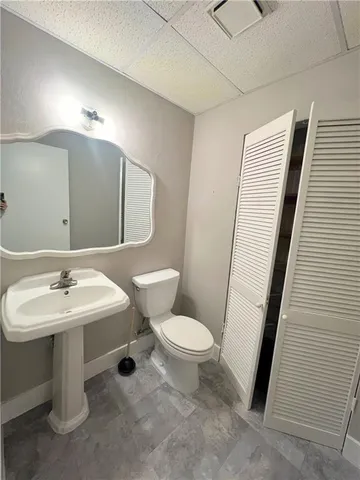 a bathroom with a toilet sink and mirror