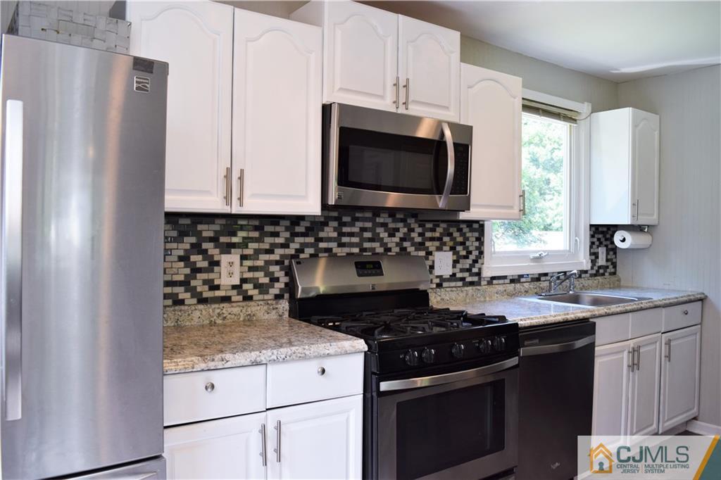 24 North Pennington Road New Brunswick, NJ 08901 - Photo 12 of 47 a kitchen with granite countertop a stove sink and microwave