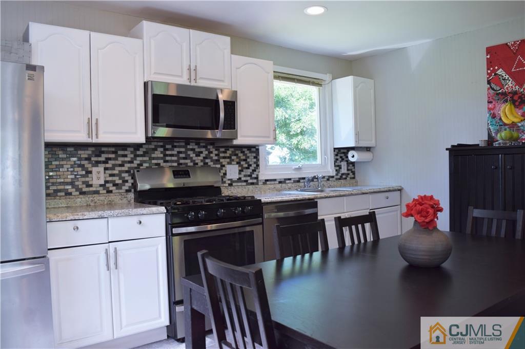 24 North Pennington Road New Brunswick, NJ 08901 - Photo 13 of 47 a kitchen with a stove a sink and a microwave