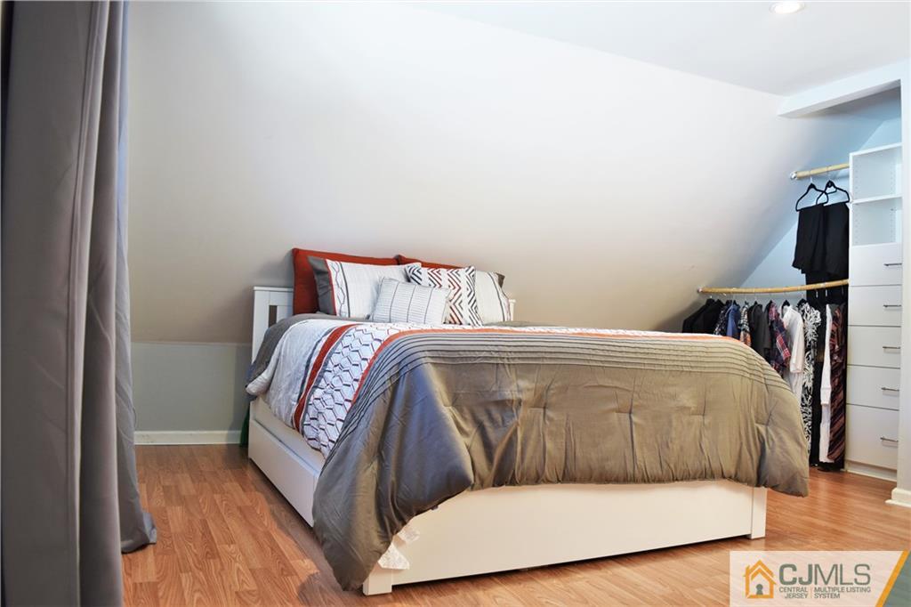 24 North Pennington Road New Brunswick, NJ 08901 - Photo 37 of 47 a bed sitting in a bedroom next to a window with a tv