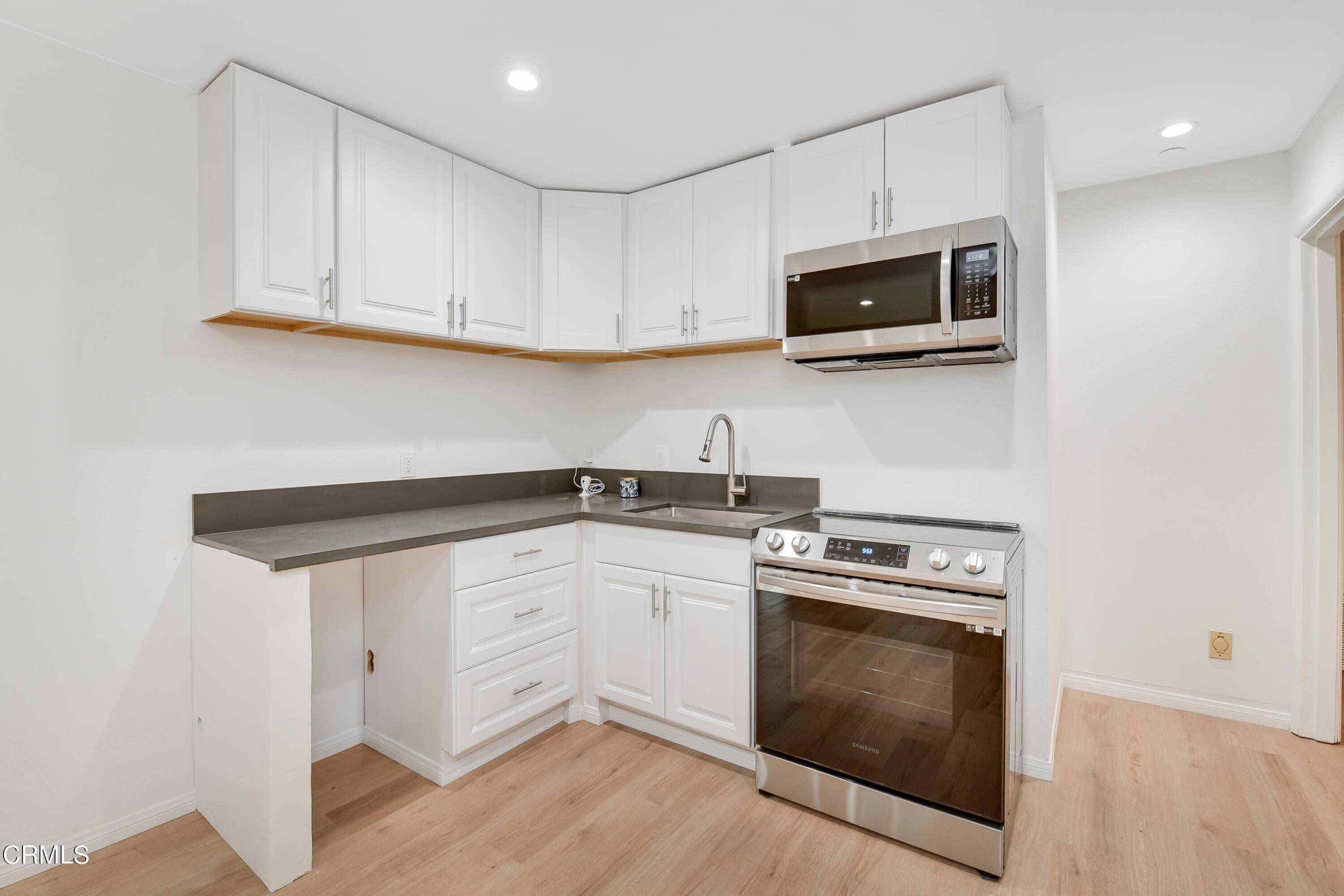 296 Foothill Drive Fillmore, CA 93015 - Photo 7 of 17 a kitchen with white cabinets and stainless steel appliances