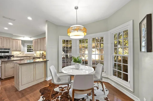 a kitchen with kitchen island granite countertop cabinets table and chairs
