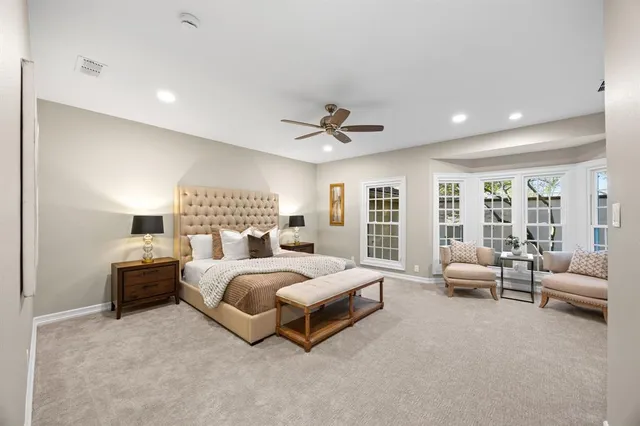 a spacious bedroom with a bed a couch and a large window