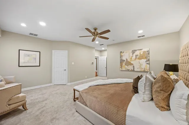 a spacious bedroom with a bed and a ceiling fan