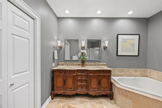 a bathroom with a granite countertop sink a large mirror and bathtub