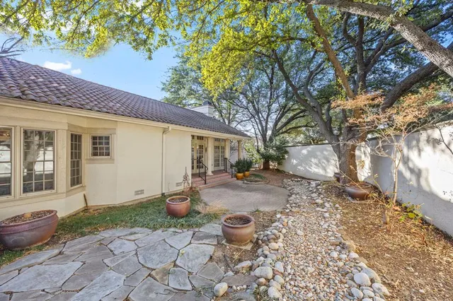 a view of a backyard with table and chairs and potted plants