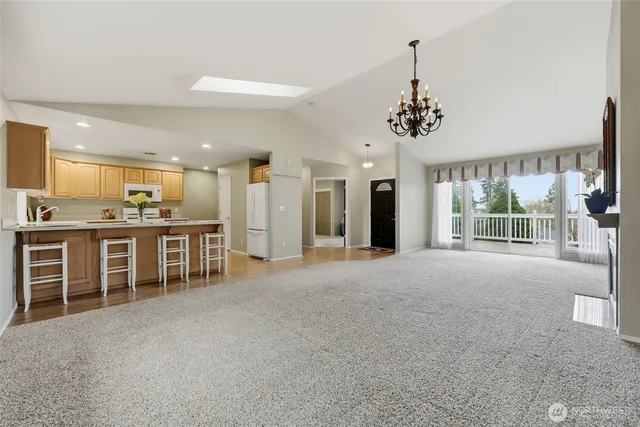 a view of a kitchen with granite countertop a refrigerator and a sink