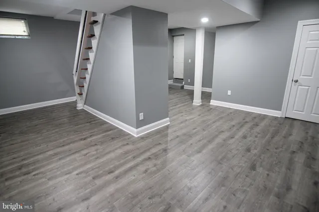 an empty room with wooden floor and entrance