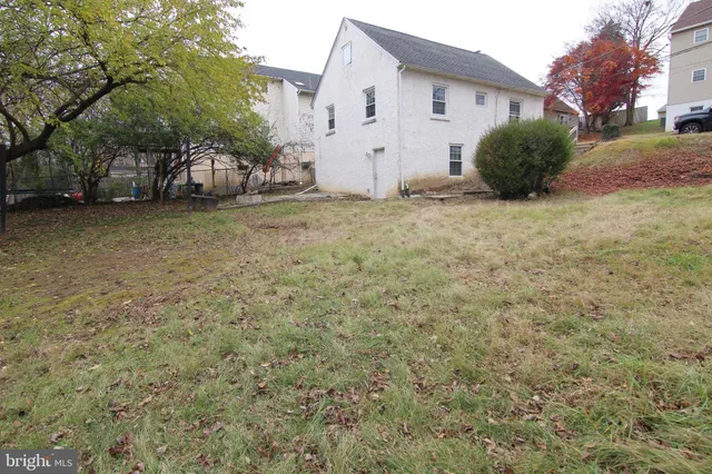 a view of a house with backyard and trees