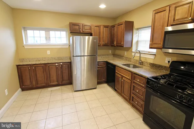 a kitchen with a stove a refrigerator and a sink