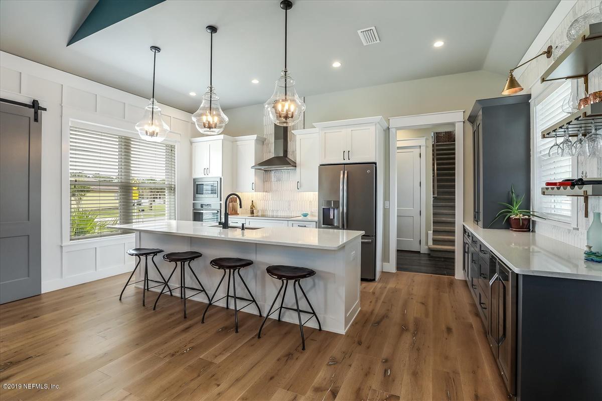 80 Ferrol Road St. Augustine, FL 32084 - Photo 7 of 32 a kitchen with stainless steel appliances granite countertop a kitchen island hardwood floor sink stove and wooden cabinets