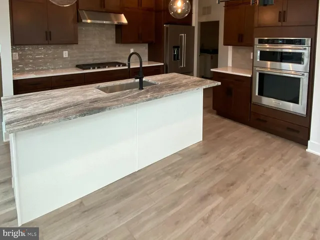 a kitchen with stainless steel appliances granite countertop a sink and a microwave