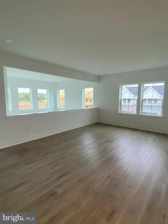 a view of empty room with window and wooden floor