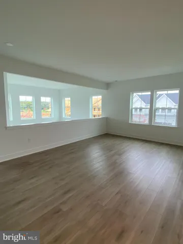 a view of empty room with window and wooden floor