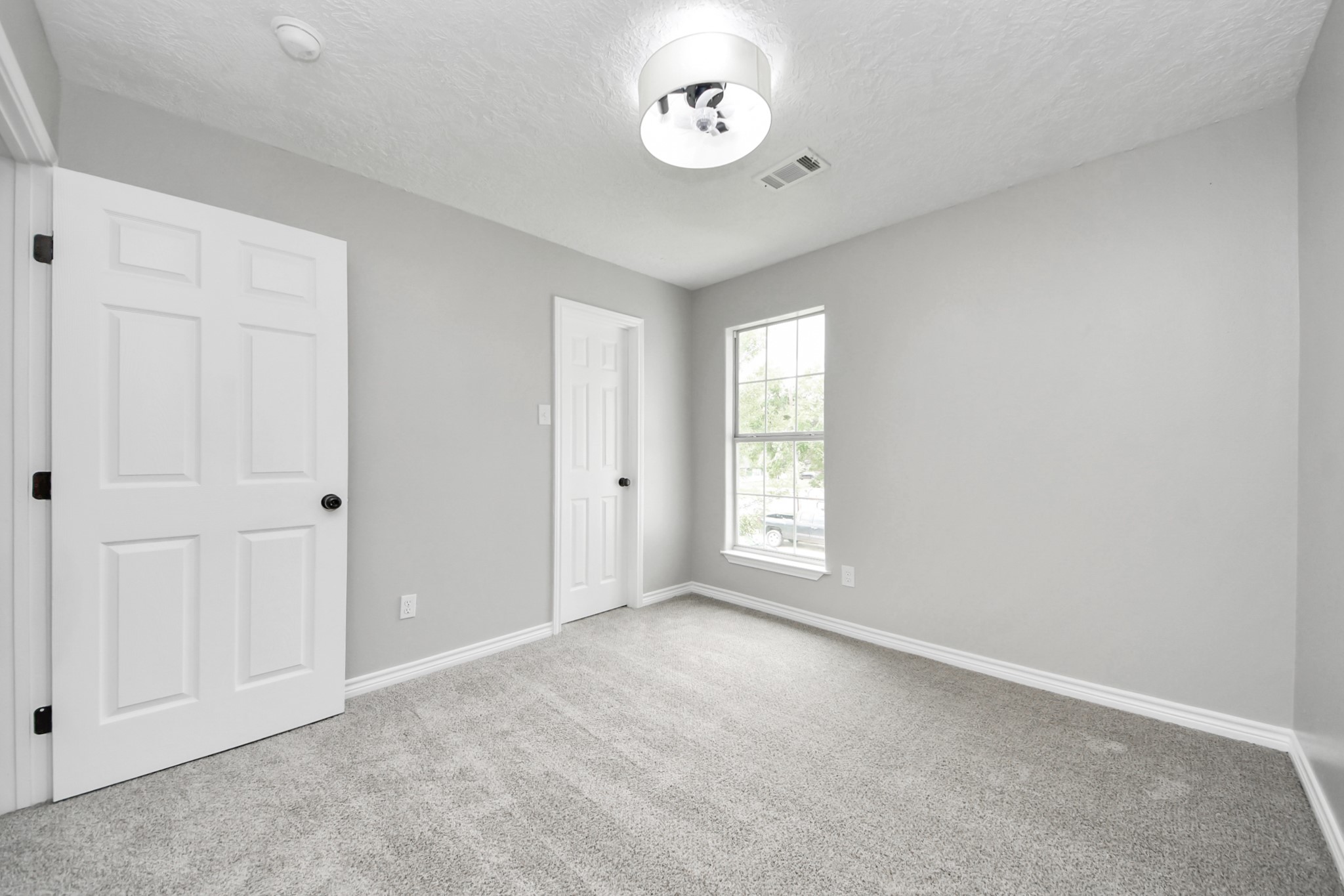 1105 East Kyle Road Clute, TX 77531 - Photo 32 of 44 This secondary bedroom has neutral gray walls, a plush carpet, and a large window providing natural light. The ceiling has a modern light fixture, and the space offers a cozy, clean feel, ideal for a bedroom or office.