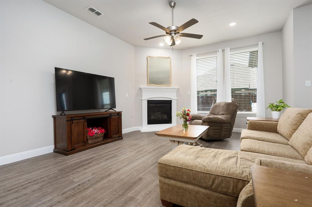1320 Rosebush Road Aubrey, TX 76227 - Photo 13 of 33 a living room with furniture a flat screen tv and a fireplace