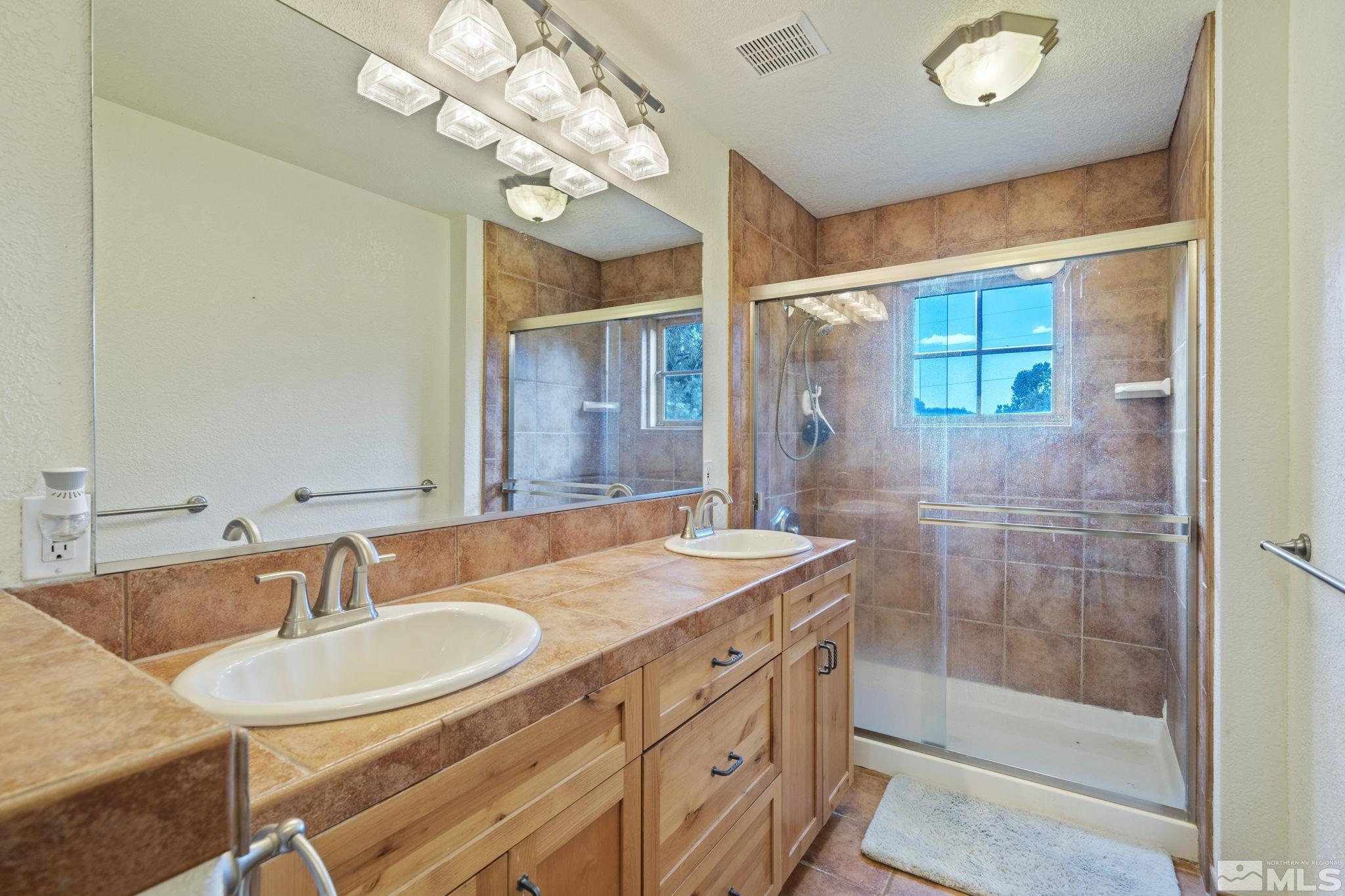 21410 Sazarac Road Reno, NV 89521 - Photo 17 of 38 a bathroom with a sink double vanity and a mirror