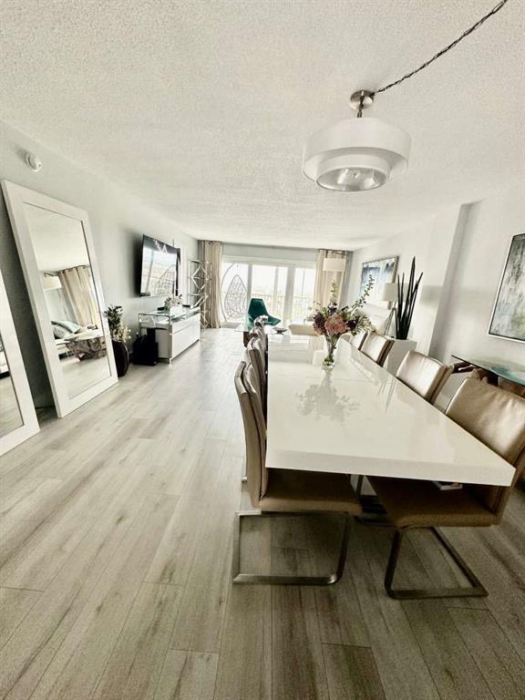 299 North Riverside Drive, Unit PH 5 Pompano Beach, FL 33062 - Photo 2 of 19 a dining room with furniture and wooden floor