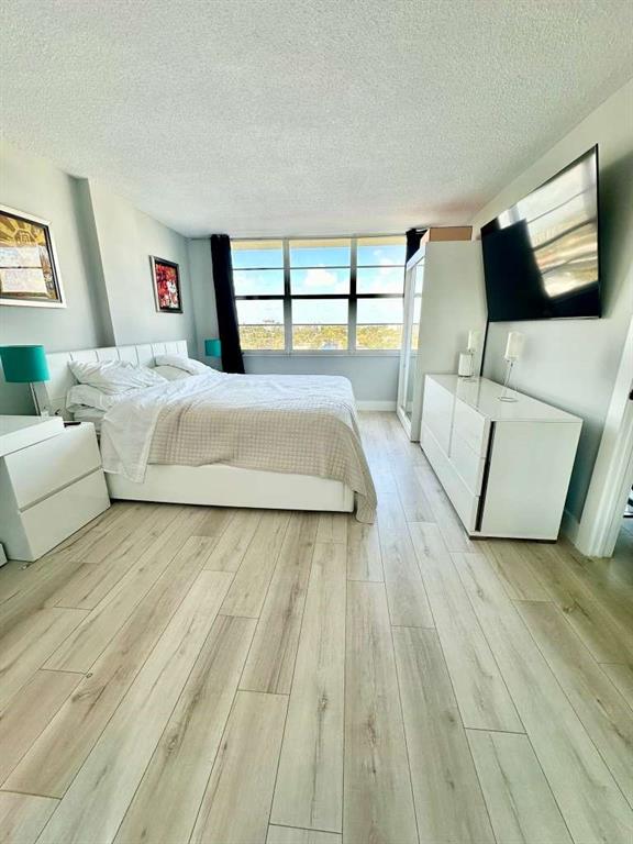 299 North Riverside Drive, Unit PH 5 Pompano Beach, FL 33062 - Photo 7 of 19 a spacious bedroom with a large bed and a flat screen tv