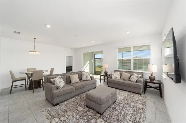 a living room with furniture flat screen tv and a large window