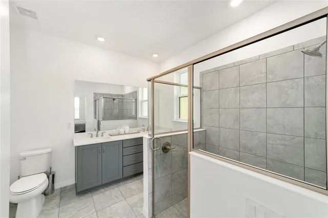 a bathroom with a sink a toilet and shower