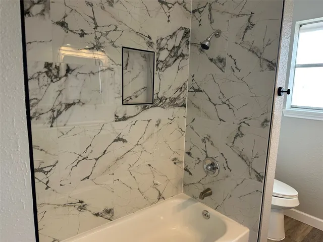 a bathroom with a bathtub and a toilet