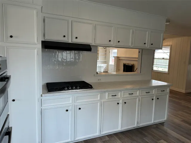 a kitchen with white cabinets appliances and a sink
