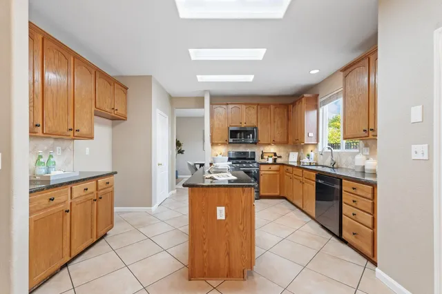 a kitchen with stainless steel appliances granite countertop a stove a sink dishwasher and a refrigerator