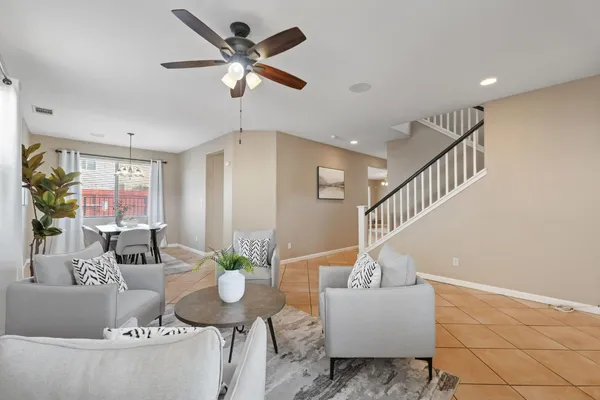 a dining room with furniture a chandelier and wooden floor