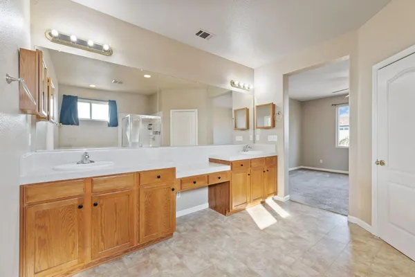 a kitchen with stainless steel appliances granite countertop a stove top oven a sink dishwasher and a refrigerator with wooden cabinets