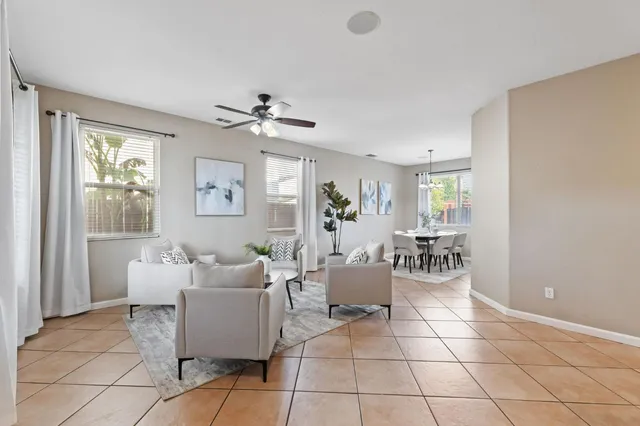 a living room with furniture a dining table and a window