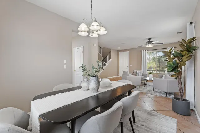 a dining room with furniture a chandelier and wooden floor
