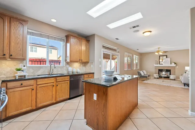 a kitchen with stainless steel appliances granite countertop a sink counter space cabinets and a large window