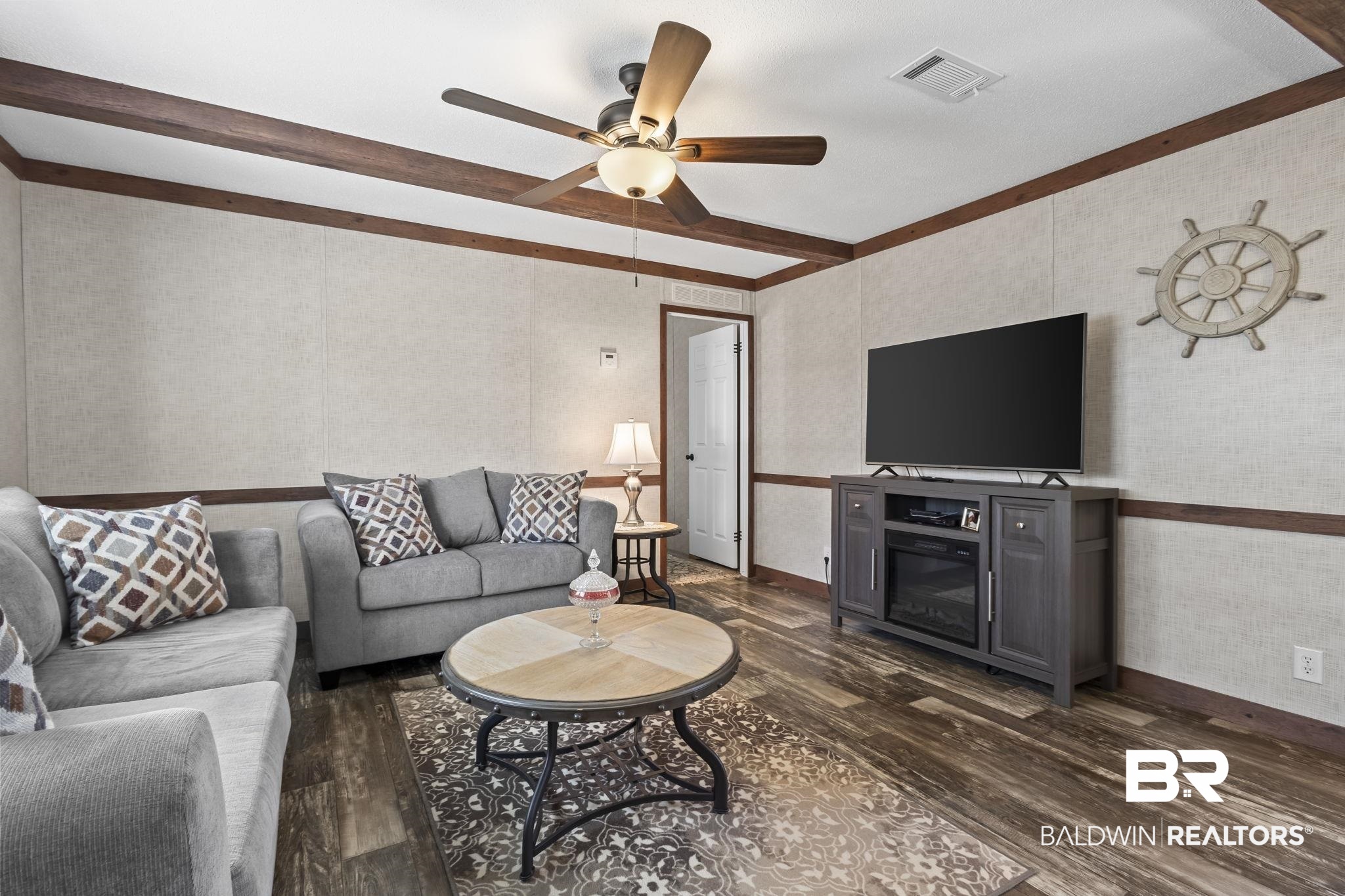 12960 7th Street Lillian, AL 36549 - Photo 10 of 25 Living room with visible vents, wallpapered walls, ceiling fan, and dark wood-style flooring