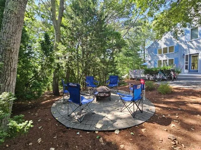 a view of a patio with table and chairs potted plants and large tree